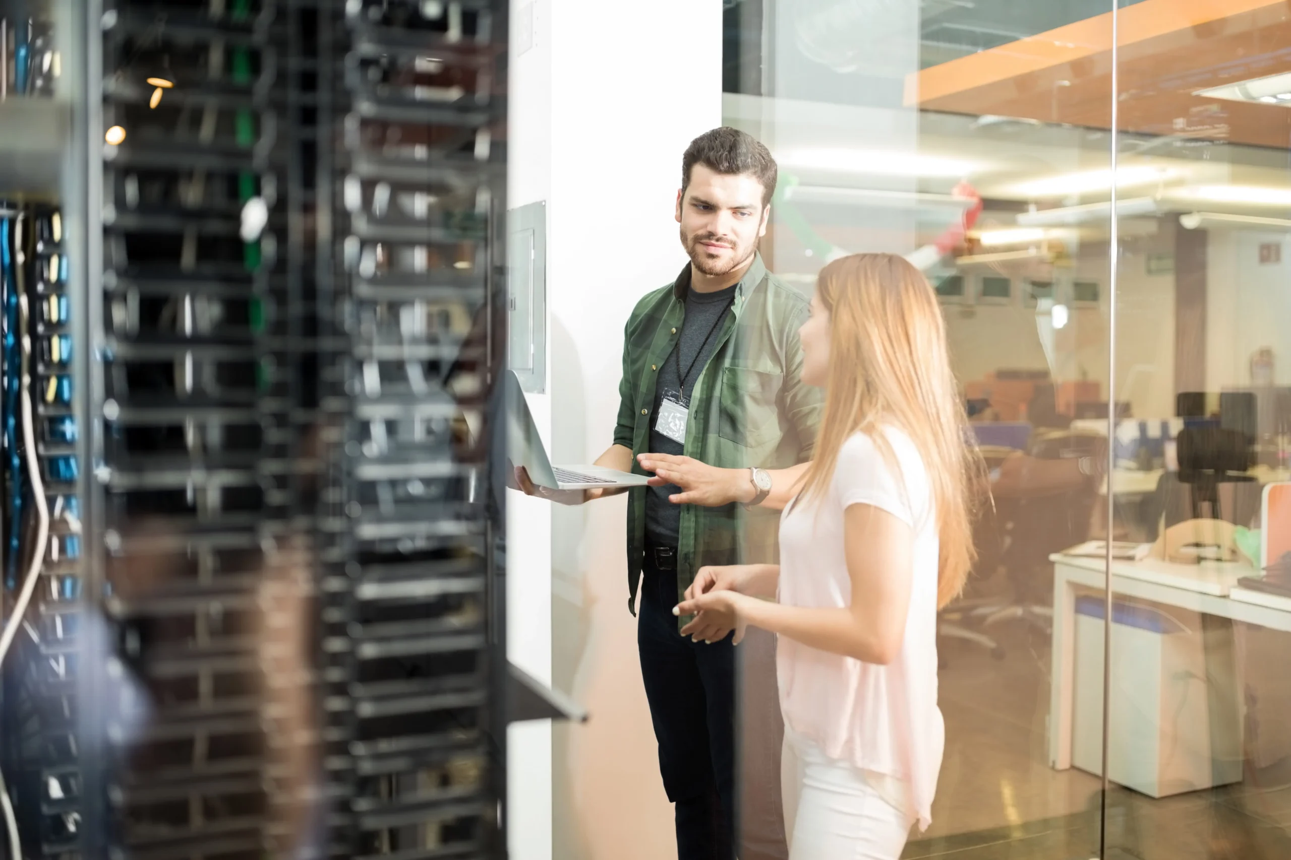 two-business-people-standing-server-room-with-laptop-discussing